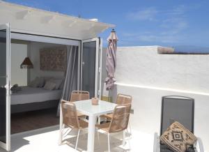 a white table and chairs on a balcony with a bed at CASA MAR GINES NORTE in La Santa