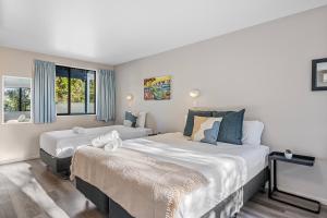 Habitación de hotel con 2 camas y ventana en Tasman Holiday Parks - Christchurch en Christchurch