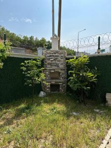 Yunuseli的住宿－YUNUSELİ 7+2 VİLLA LUXURY，围栏旁的院子中的砖炉