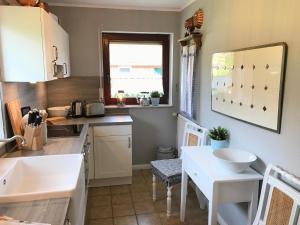 eine kleine Küche mit einem Waschbecken und einem Tisch in der Unterkunft Ferienhaus für 4 Personen ca 100 m in Hage, Nordseeküste Deutschland Ostfriesland in Hage