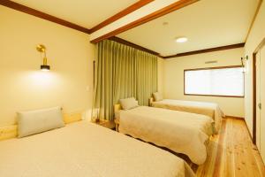 um quarto de hotel com duas camas e uma janela em 川の灯 em Yumachi