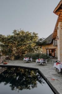 een patio met tafels en stoelen voor een gebouw bij Inkungu Lodge in Champagne Valley