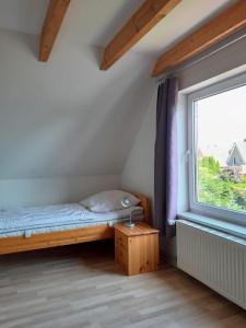 ein kleines Schlafzimmer mit einem Bett und einem Fenster in der Unterkunft Ferienwohnung für 6 Personen ca 95 m in Emden, Nordseeküste Deutschland Ostfriesland in Emden