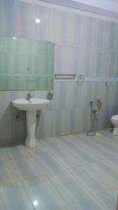 y baño con lavabo, espejo y aseo. en Overseas B&B Guest House, en Islamabad