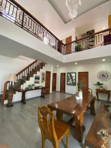 a living room with a wooden table and stairs at Beachfront Mansion and Seascape Villas Calatagan with Outdoor Pool in Calatagan