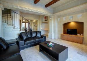 Una sala de estar con un sofá y una mesa de café. en Villa Cara, en Għarb