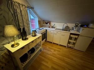a small kitchen with a table with a lamp on it at Bjarmaland in Vestmannaeyjar