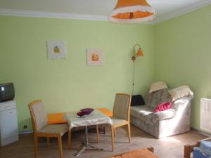 - un salon avec un canapé, une table et des chaises dans l'établissement Appartement in Ueckermünde mit Grill, à Ueckermünde