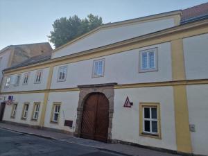 a large white building with a brown door at Apartmán Anežka -1- in Jičín