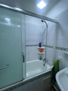 a bathroom with a shower and a tub and a sink at Bab Ezzouar in Bab Ezzouar
