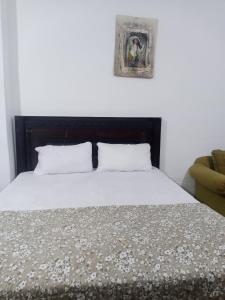 a bed with two pillows in a bedroom at Flower 2 in Jerash