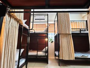 Tuna Homestay Hanoi & Experience في هانوي: غرفة بسريرين بطابقين مع ستائر
