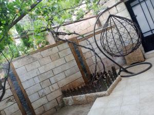 a metal basket on the side of a brick wall at Flower 2 in Jerash