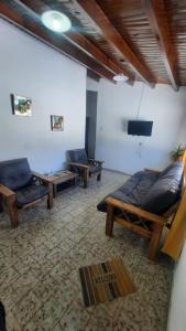 ein Wohnzimmer mit Sofas und einem Flachbild-TV in der Unterkunft Eduardo in Malargüe
