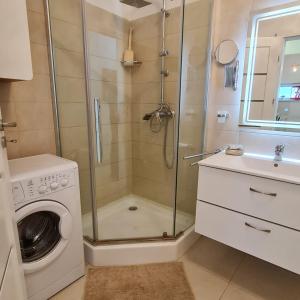a bathroom with a shower and a washing machine at CRISTINCO PANORAMIC in Cluj-Napoca +21 photos