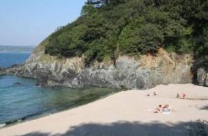 a group of people laying on a beach near the water at Tente 2 places installée sur emplacement commun in Plestin-les-Grèves +5 photos