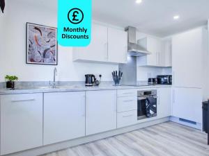 a kitchen with white cabinets and the words mummy discounts at 2 Bedroom 2 Bathroom in ASHFORD - Next to Station - Perfect for 6 people - Parking & Super Fast Internet in Ashford