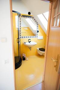 uma casa de banho amarela com um lavatório e um WC em Kamień Pomorski Homely House em Kamień Pomorski