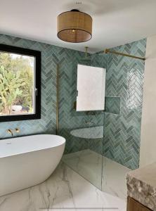 baño con lavabo, bañera y ventana en Stylish luxury villa near Sitges, en Olivella 31 fotos más