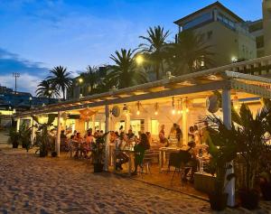 un grupo de personas sentadas en mesas en un restaurante en Stylish luxury villa near Sitges, en Olivella