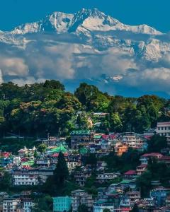 vistas a una ciudad con una montaña en el fondo en New Sangam Homestay, en Darjeeling