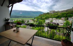 a balcony with a table and a view of a city at Emblematic House Apartment 1 in Gjirokastër