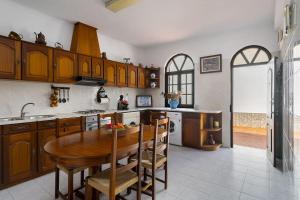 een keuken met een houten tafel en een aantal stoelen bij Villa Oasis - Pool & Garden in Santa Marta