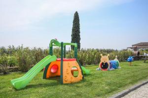 un groupe d'équipements de terrain de jeu sur l'herbe dans l'établissement Ferienwohnung in Moniga Del Garda mit gemeinsamem Pool und Garten und Seeblick, à Moniga del Garda