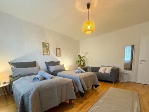 ein Wohnzimmer mit 2 Betten und einem Sofa in der Unterkunft revLIVING Kaiser Franz Septima Altstadt Apartment Baden in Baden