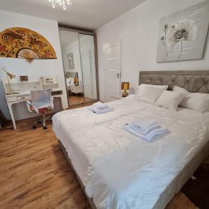 a bedroom with a large white bed with towels on it at CRISTINCO PANORAMIC in Cluj-Napoca