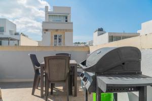 una parrilla en un patio con sillas y mesa en Lovely Penthouse in Gzira, en Il-Gżira 8 fotos más