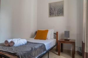 Un pequeño dormitorio con una cama y una mesa. en Lovely Penthouse in Gzira, en Il-Gżira