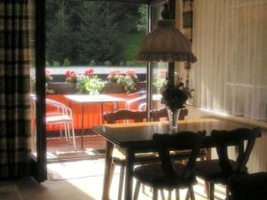 una sala da pranzo con tavolo e sedie e un patio di Ferienwohnung Oberstaufen a Oberstaufen