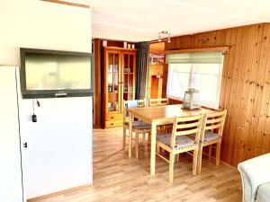 a dining room with a wooden table and chairs at Ferienhaus Balu mit eigenem Steig direkt am Wasser IJsselmeer in Wervershoof