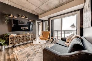 a living room with a couch and a large window at Le Dark Luxury nice view and rooftop pool in Quebec City