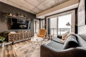 een woonkamer met een bank en een groot raam bij Le Dark Luxury nice view and rooftop pool in Québec