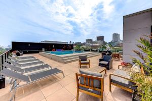 a patio with chairs and a swimming pool on a building at Le Dark Luxury nice view and rooftop pool in Quebec City