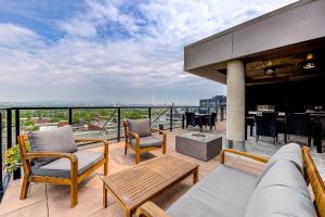 d'un balcon avec un canapé, des chaises et une table. dans l'établissement Le Dark Luxury nice view and rooftop pool, à Québec