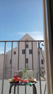 a table on a balcony with a view of a building at Nonno Nicola Rooms in Bari