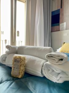 una pila de toallas sentadas encima de una cama en Nonno Nicola Rooms, en Bari