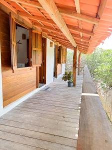 a wooden porch of a house with a wooden roof at Atins Beach Houses in Atins
