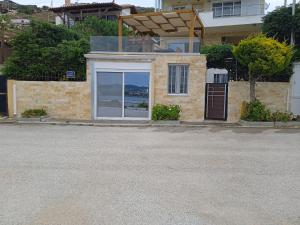 een huis met een raam met uitzicht op de oceaan bij PRIVATE SEASIDE GUEST HOUSE... in Agia Marina Mikrolimanou