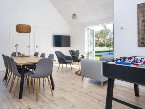a dining room with a table and a pool table at 8 person holiday home in Rømø in Kongsmark