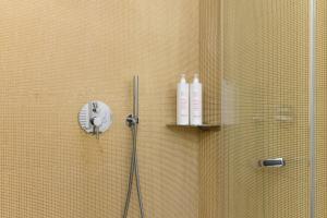 una ducha con 2 botellas en una pared de azulejos en Unico B&B Art Decor, en Ostuni
