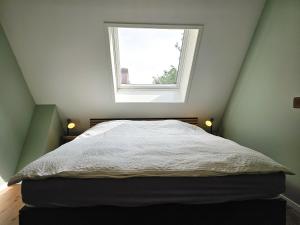 1 dormitorio con 1 cama y ventana en Vakantiewoning Otje AK15 Aagtekerke, en Aagtekerke
