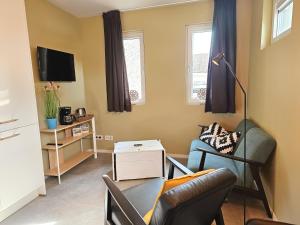 アーフテーケルケにあるVakantiewoning Otje AK15 Aagtekerkeのソファと椅子のあるリビングルーム