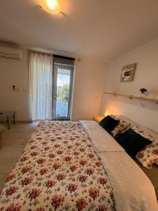 - une chambre avec un grand lit à motifs floraux dans l'établissement Apartments Mirjana, à Piran
