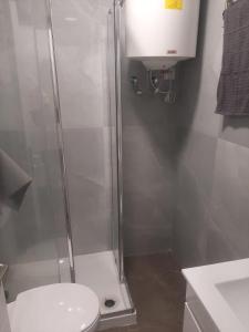 a bathroom with a shower with a toilet and a sink at Plaza Caparica Hostel in Costa da Caparica +62 photos