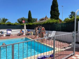 un grupo de personas parados junto a una piscina en Villa Alba en Fermo