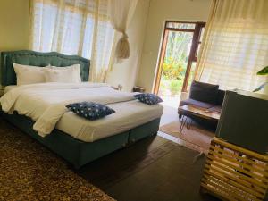 a bedroom with a large bed with pillows on it at Afro Smile Hotel and Guest House in Jinja